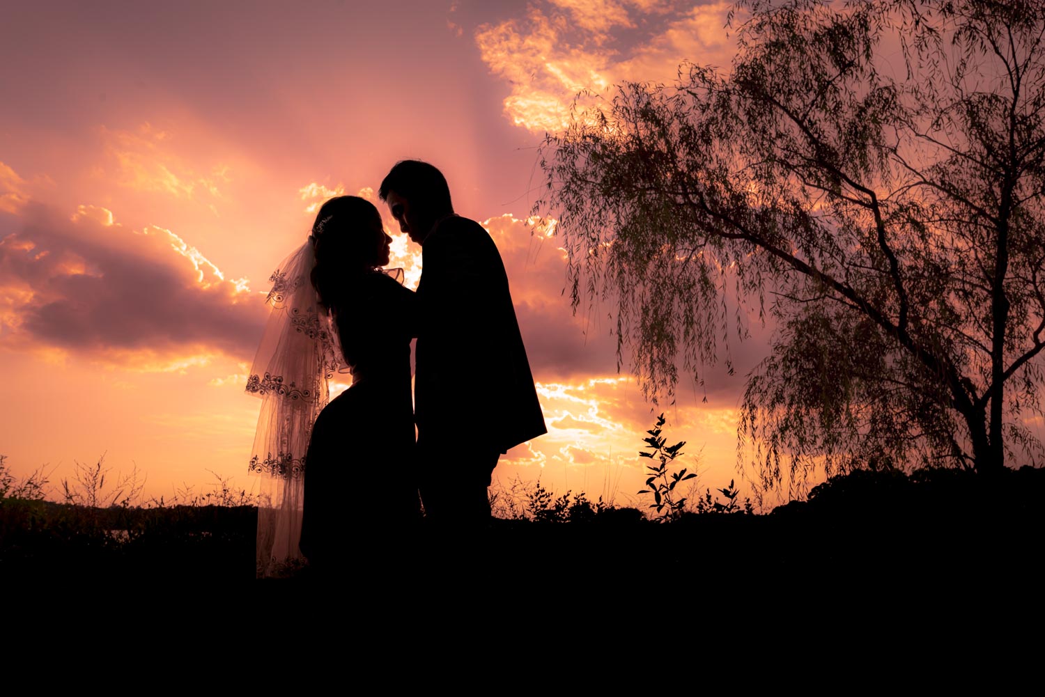 Silhouette dancing couple by the lake